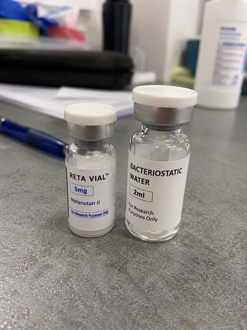 A vial of Retatrutide peptide beside bacteriostatic water